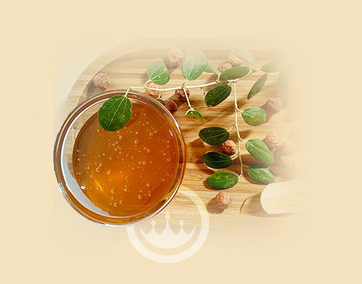 image of yemeni sidr honey in glass on wodden tray with sidr leaves and sidr fruits - prestige provisions