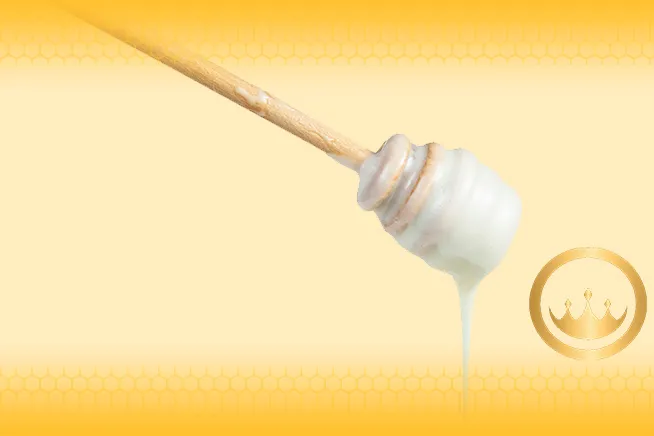 white honey attached to wooden dipper