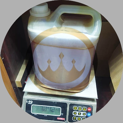 shipping grade jerry can filled with premium yemeni sidr honey on a scale that reads 7.042kg